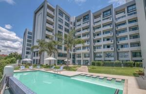 a large apartment building with a large swimming pool at The Regency Cosy Apartment- 419 in Pretoria