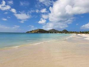 a view of a beach with people in the water at Sugarhill in Jolly Harbour