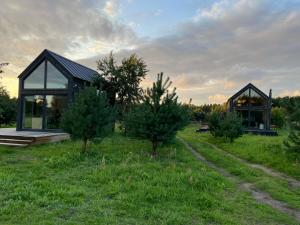 a house in a field with trees in front of it at Your Private Hytte in Smołdzino