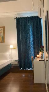 a bedroom with a bed and a blue curtain at Suitedream Vatican in Rome