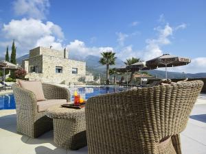 a patio with chairs and an umbrella and a pool at Anaxo Resort in Riglia