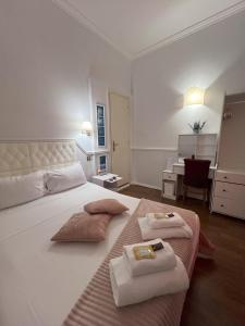 a bedroom with a large white bed with two folded towels at Suitedream Vatican in Rome