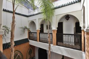 un edificio con un balcón con palmeras. en Riad 22 - L'Etoile d'Orient en Marrakech