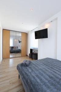 1 dormitorio con 1 cama y TV en la pared en ClickTheFlat Chłodna Center Apart Rooms, en Varsovia