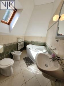 a bathroom with a toilet and a sink and a tub at Szarvas Panzió in Erdőbénye +12 photos