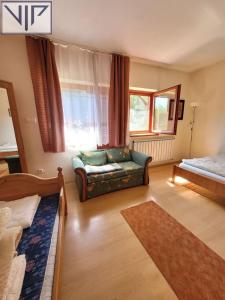 a living room with a couch and a window at Szarvas Panzió in Erdőbénye