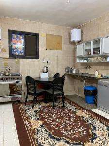 Madinah Anbariah في المدينة المنورة: مطبخ مع طاولة وكراسي في مطبخ