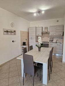 a kitchen with a dining room table and chairs at Flowers Apartment in Villa Caldari