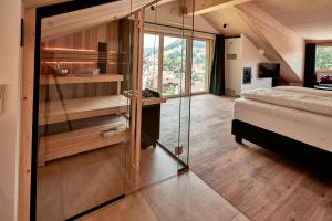 a bedroom with a bed and a glass wall at Staufen Chalets am Schlossberg in Oberstaufen
