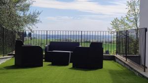 un patio con sillas y una valla con césped verde en WikiLoft, en Lucignano
