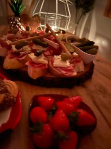 a table with a plate of food with strawberries on it at Apartments and Wellness Ščavničar in Ljutomer