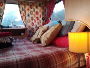 een bed in een kamer met kussens erop bij Retro caravan 