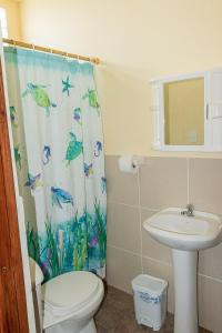 a bathroom with a sink and a toilet and a shower curtain at San Alejo Zero in San Jacinto