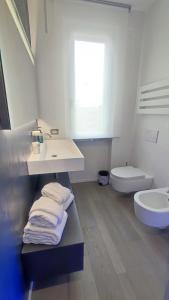 Baño blanco con lavabo y aseo en WikiLoft, en Lucignano