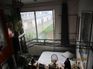 sypialnia z łóżkiem i dużym oknem w obiekcie STUDIO ORANGE CINEMATIC 59 w mieście Charleville-Mézières