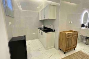 eine weiße Küche mit einer Spüle und einer Theke in der Unterkunft شقة حي العقيق قريبة البوليفارد in Riad