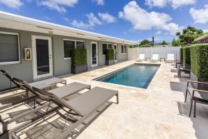 - une piscine avec des chaises longues et des chaises à côté d'une maison dans l'établissement Wiltonplex D, à Fort Lauderdale