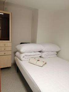 łóżko z białymi poduszkami i ręcznikami w obiekcie Hostel WAWA More w Warszawie