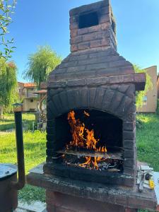 an outdoor brick oven with fire in it at Venus Resort in Dumbrăviţa