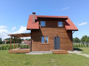 Casa de madera con porche y terraza en Klimatyczny Domek - całoroczny, en Rydzewo