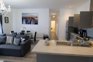 a kitchen and living room with a couch and a sink at Milton Keynes Love Home in Bletchley