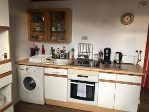 een keuken met een spoelbak en een wasmachine bij Appartement côte des basques in Biarritz +17 foto's
