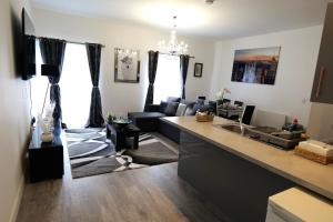 a kitchen and living room with a sink and a couch at Milton Keynes Love Home in Bletchley