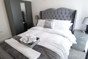 a bedroom with a white bed with a cross on it at Milton Keynes Love Home in Bletchley