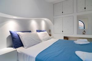 ein Schlafzimmer mit einem großen Bett mit blauen und weißen Kissen in der Unterkunft Shape-Spiral in Kalymnos
