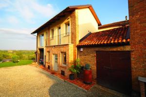 a brick house with a garage and a driveway at Vita Bella in Castagnole Monferrato