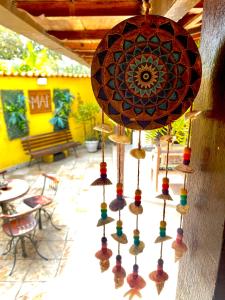 a chandelier with different colored beads hanging from a wall at MAI Chameguin Hospedagens Paraty in Paraty