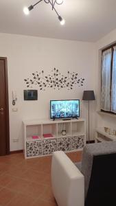 sala de estar con TV de pantalla plana en la pared en La Dama di Fiori, en Verolanuova