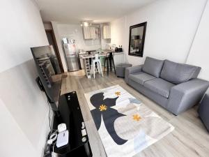 sala de estar con sofá y cocina en Comoda Estadia en Talcahuano, en Talcahuano