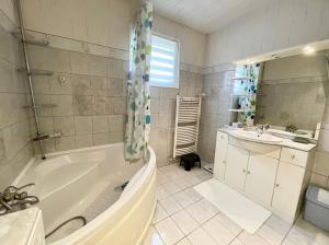 La salle de bains est pourvue d'une baignoire et d'un lavabo. dans l'établissement La Casa - Charmante maison entre Paris & Disney, à Noisy-le-Grand