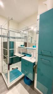 La salle de bains est pourvue de placards bleus et d'une douche en verre. dans l'établissement La Casa - Charmante maison entre Paris & Disney, à Noisy-le-Grand