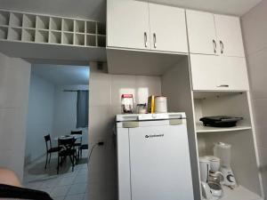 uma cozinha com um frigorífico branco e uma mesa em Apartamento inteiro próximo a Algar, Cargill, Aeroporto e UFU em Uberlândia