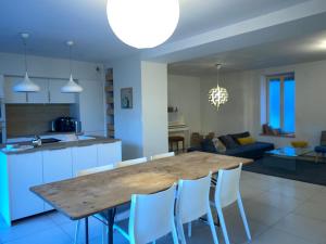 een keuken en woonkamer met een houten tafel en stoelen bij La maison Familiale in Dijon