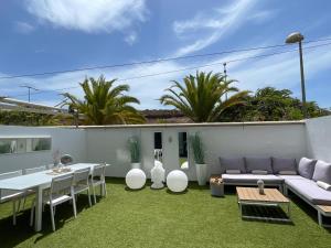 une terrasse avec un canapé, une table et des chaises dans l'établissement Luxury Avilla Las Olas, à Palm-mar