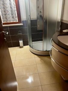 a bathroom with a shower and a tiled floor at Appartamento in casale rustico - La Masseria in Busso +18 photos