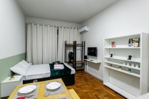 里約熱內盧的住宿－Temporada Flamengo - Metrô e Conforto!，一间卧室配有一张床、一张书桌和一台电视