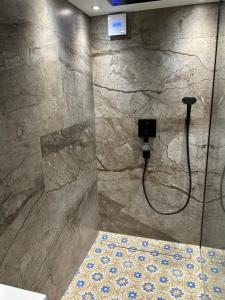 a bathroom with a shower with a stone wall at Doppelbett Suite, nähe Messe in Düsseldorf