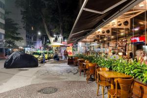 里約熱內盧的住宿－Temporada Flamengo - Metrô e Conforto!，夜间在街上的一家餐厅,那里有桌椅