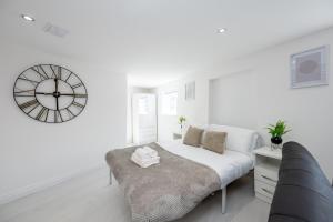 um quarto branco com uma cama e um grande relógio em Modern Studio Apartment Kings Lynn em King's Lynn