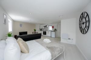 a white bedroom with a large bed and a kitchen at Modern Studio Apartment Kings Lynn in King's Lynn