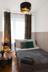 sypialnia z łóżkiem i dużym oknem w obiekcie ClickTheFlat Three Crosses Square Apart Rooms w Warszawie