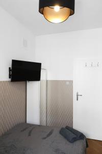 a bedroom with a bed and a flat screen tv at ClickTheFlat Three Crosses Square Apart Rooms in Warsaw