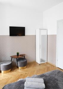 a living room with a tv and a table and stools at ClickTheFlat Three Crosses Square Apart Rooms in Warsaw