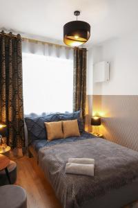 sypialnia z łóżkiem i dużym oknem w obiekcie ClickTheFlat Three Crosses Square Apart Rooms w Warszawie