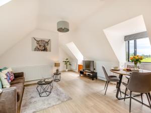 a living room with a couch and a table at Woodlands Annexe in West Pennard