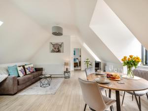 een woonkamer met een tafel en een bank bij Woodlands Annexe in West Pennard